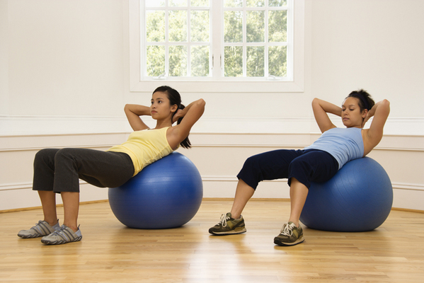 Women doing exercise ball workouts at home